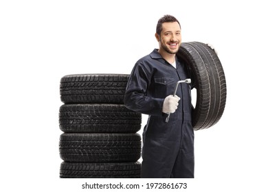 Smiling Auto Mechanic Man Holding A Tire And A Lug Wrench Isolated On White Background