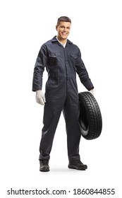 Smiling Auto Mechanic In A Uniform Holding A Car Tire Isolated On White Background