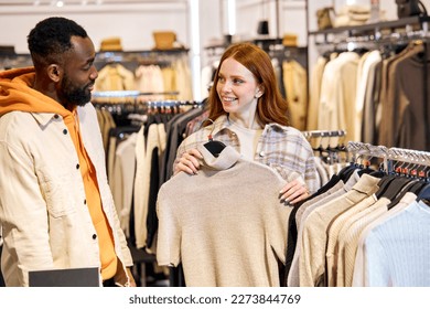 smiling awesome beautiful shop assistent offer outfit for american stylish bearded man, seller gives advice what to buy for buyer. close up side view photo. commerse, trade, black friday - Powered by Shutterstock