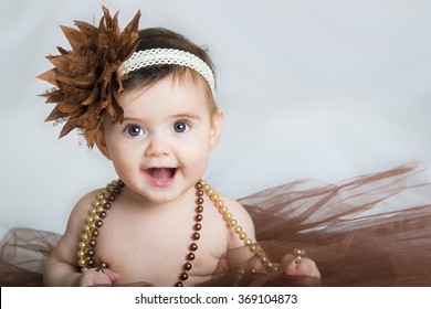 Smiling Baby Ballerina In Brown Tutu With A Pearl Necklace