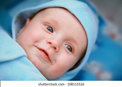 Smiling Baby Boy With Big Blue Eyes Close Up