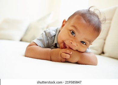 Smiling Baby Boy Lying On Tummy At Home