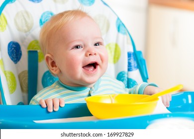 Smiling Baby Eating Food On Kitchen