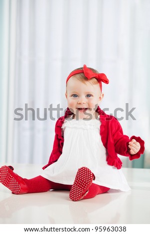 Smiling baby girl dressed in red and white