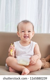 Smiling Baby Girl Eating Friut Slices With Plastic Fork