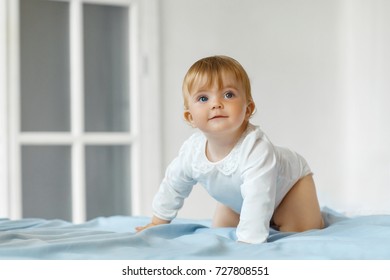 Smiling Baby Girl Sit On The Bed