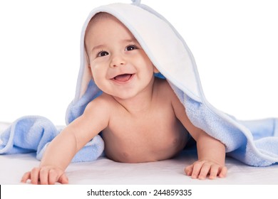 Smiling Baby Lying On Bed Under Towel Isolated