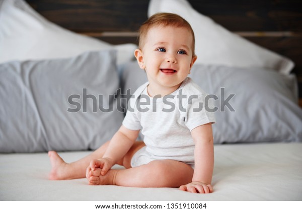 Bebe Souriant Assis Sur Son Lit Photo De Stock Modifiable