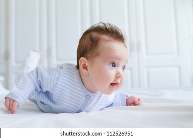 Smiling Baby Tummy Time In A White Nursery