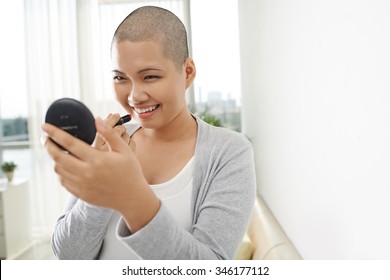 Smiling Bald Asian Woman Applying Red Lipstick