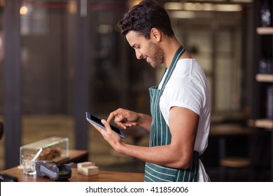 Smiling barista using tablet in the bar - Powered by Shutterstock