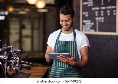 Smiling Barista Using Tablet In The Bar