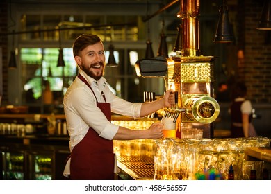 Smiling Bartender Pours A Beer Indoors