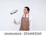 A smiling bartender tosses a cocktail shaker in the air, showcasing bartending skills and a fun, engaging atmosphere. Isolated on a white background.