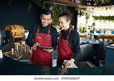 Smiling bartenders checking orders on tablet computer - Powered by Shutterstock