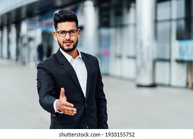 Smiling bearded Indian man reaches out to the camera, invites to work, modern and successful Indian businessman man.