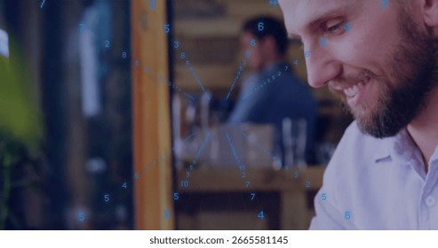 Smiling bearded man analyzing data overlay on tablet at workspace with wooden partition, copy space. Technology, collaboration, modern, analytics, professional, workspace, network