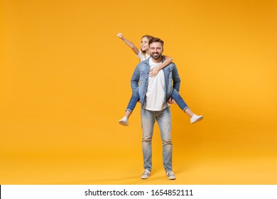 Smiling bearded man with child baby girl. Father little kid daughter isolated on yellow background. Love family parenthood childhood concept. Give piggyback ride to joyful sit on back clenching fist