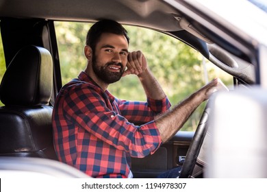 Smiling Bearded Man Driving Pickup Truck In Forest