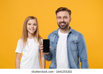 Smiling Bearded Man Have Fun With Child Baby Girl. Father Little Kid Daughter Isolated On Yellow Background. Love Family Day Parenthood Childhood Concept. Hold Mobile Phone With Blank Empty Screen