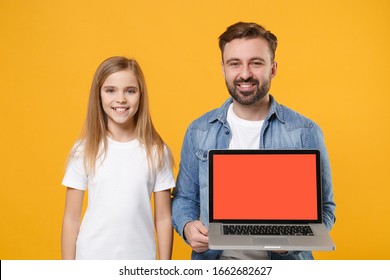 Smiling Bearded Man Have Fun With Child Baby Girl. Father Little Kid Daughter Isolated On Yellow Background. Love Family Day Parenthood Childhood Concept. Hold Laptop Computer With Blank Empty Screen