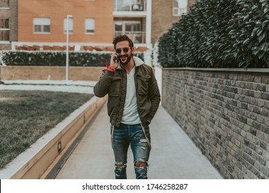Smiling, bearded man talking on the phone while walking in the city