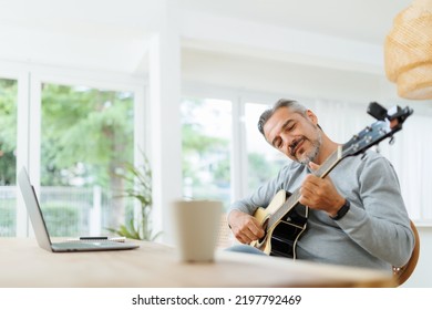 Smiling Bearded Musician Mature Adult Man Playing Acoustic Guitar, Using Laptop