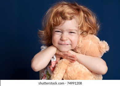 Smiling Beautiful Child Embraces Teddy Bear