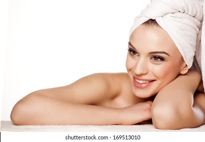 smiling beautiful girl with a towel on her head posing in lying position