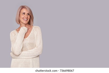 Smiling Beautiful Old Woman Looking Up To Copy Space. Isolated On Grey