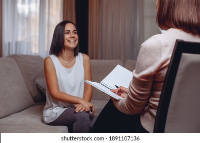 Smiling beautiful patient sitting at a psychologist's appointment. Psychotherapy and psychocorrection. Success concept
