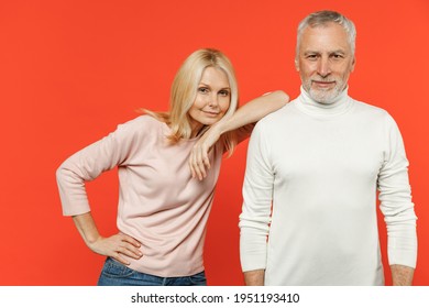 Smiling beautiful pretty couple two friends elderly gray-haired man blonde woman wearing white pink casual clothes standing looking camera isolated on bright orange color background studio portrait Stockfoto