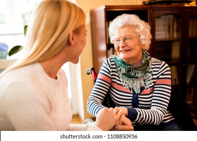 Smiling Beautiful Senior Happy Woman With Her Daughter Enjoy Talking At Home