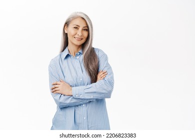 Smiling Beautiful Senior Korean Woman, Looking Self-assured And Confident, Concept Of Wellness And People Wellbeing, Standing Over White Background.