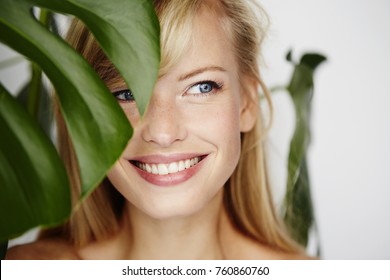 Smiling Beautiful Woman Behind Leaf, Looking Away