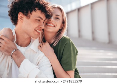 Smiling beautiful woman and her handsome boyfriend. Couple in casual summer clothes. Happy cheerful family. Female and man having fun. They posing in the street in sunny day. Sit at stairs - Powered by Shutterstock