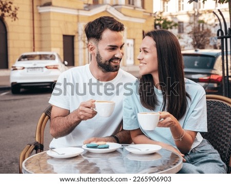 Smiling beautiful woman and her handsome boyfriend. Happy cheerful family. Couple drinking coffee in restaurant. They drinking tea at cafe in street. Holding cup. Enjoying their date