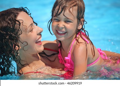 Smiling beautiful woman and little girl bathes in pool - Powered by Shutterstock