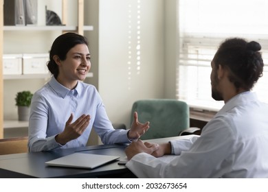 Smiling beautiful young indian ethnicity patient talking with professional african biracial family doctor therapist physician, discussing illness treatment or vaccination at checkup meeting in clinic. - Shutterstock ID 2032673654