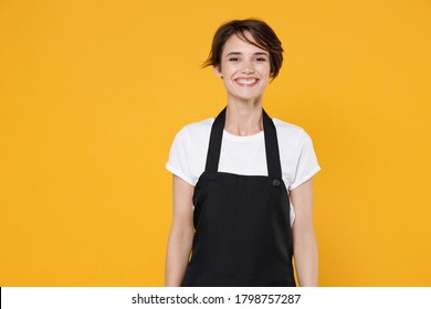 Smiling Beautiful Young Woman 20s Barista Bartender Barman Employee In White T-shirt Apron Working In Coffee Shop Posing Looking Camera Isolated On Yellow Color Background Studio Portrait