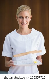 Smiling Beauty Therapist Holding White Towels At The Spa