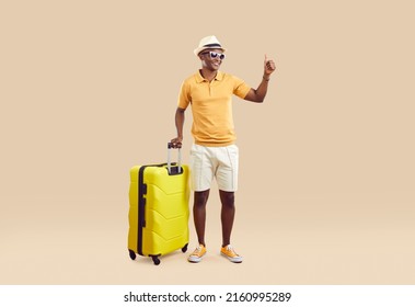 Smiling Biracial Male Traveler With Suitcase Isolated On Nude Brown Studio Background Show Thumb Up. Happy African American Man Client Recommend Good Summer Vacation. Travel And Tourism.