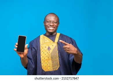 Smiling Black African Man Holding And Pointing At Mobile Phone In Hand