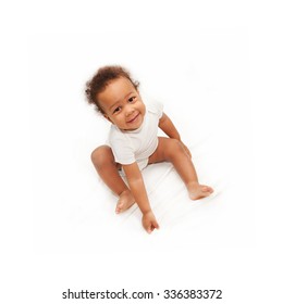 Smiling Black  Baby Sitting On White Bed