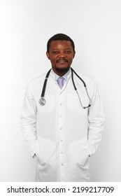 Smiling Black Bearded Doctor Man In White Coat With Stethoscope Isolated On White Background. Friendly Adult Black African American Physician Therapist Portrait, Pleasant Candid Male Emotion