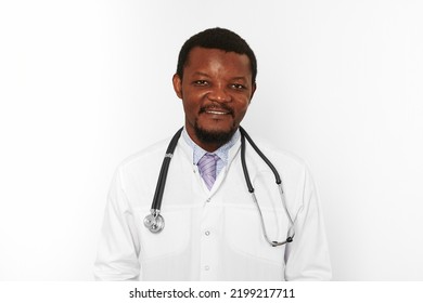 Smiling Black Bearded Doctor Man In White Coat With Stethoscope Isolated On White Background. Friendly Adult  African American Physician Therapist Portrait, Pleasant Candid Male Emotion