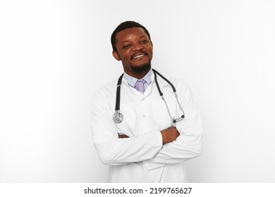 Smiling Black Bearded Doctor Man Crossed Arms In White Coat With Stethoscope Isolated On White Background. Adult Black African American Physician Therapist Portrait, Confident Candid Male Emotion