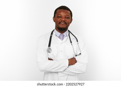 Smiling Black Bearded Doctor Man Crossed Arms In White Coat With Stethoscope Isolated On White Background. Adult Black African American Physician Therapist Portrait, Confident Candid Male Emotion