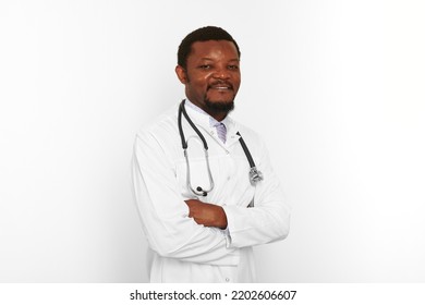 Smiling Black Bearded Doctor Man Crossed Arms In White Coat With Stethoscope Isolated On White Background. Adult Black African American Physician Therapist Portrait, Confident Candid Male Emotion