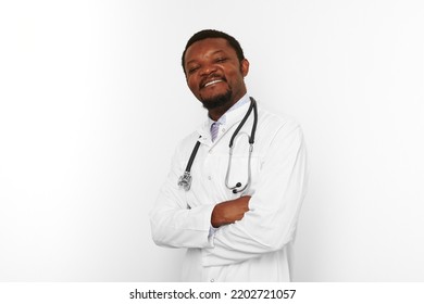 Smiling Black Bearded Doctor Man Crossed Arms In White Coat With Stethoscope Isolated On White Background. Adult Black African American Physician Therapist Portrait, Confident Candid Male Emotion